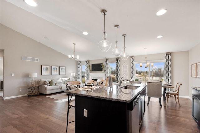 kitchen with an inviting chandelier, dark wood finished floors, a sink, visible vents, and dishwasher