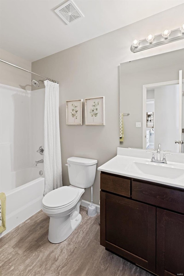 full bathroom featuring vanity, toilet, visible vents, shower / bath combo with shower curtain, and wood finished floors