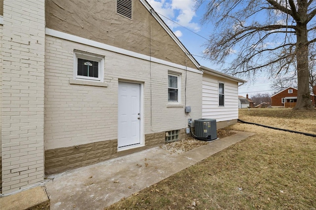 rear view of property featuring central AC unit and brick siding
