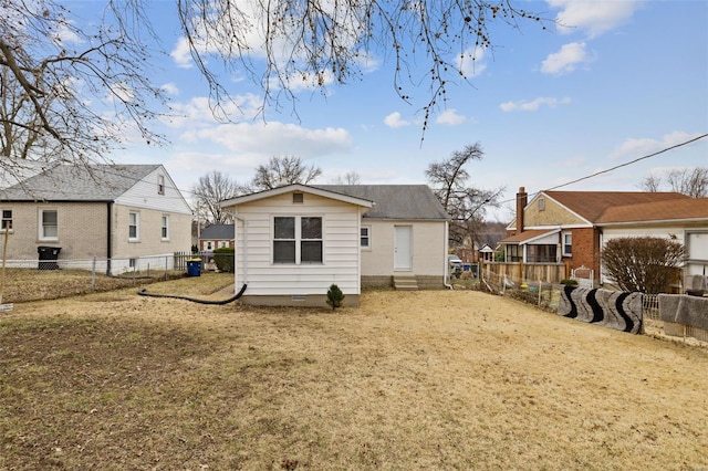 rear view of property with a fenced backyard, a residential view, and a lawn