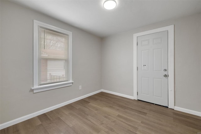 unfurnished room with baseboards and wood finished floors