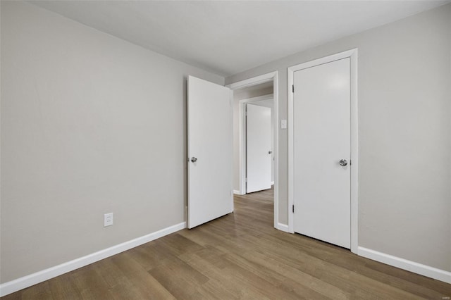 unfurnished bedroom featuring baseboards and wood finished floors