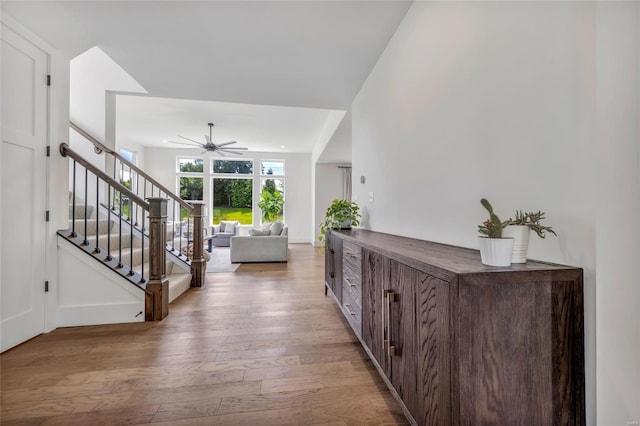 entryway featuring ceiling fan, light wood-style floors, and stairs