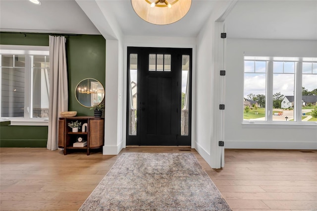 entryway featuring visible vents, baseboards, and wood finished floors