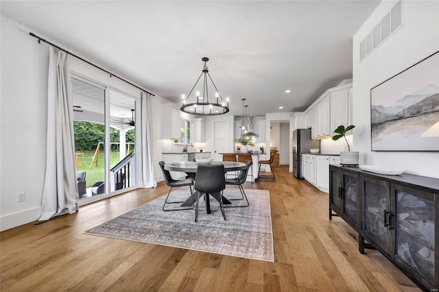dining area with baseboards, an inviting chandelier, recessed lighting, light wood-style floors, and visible vents