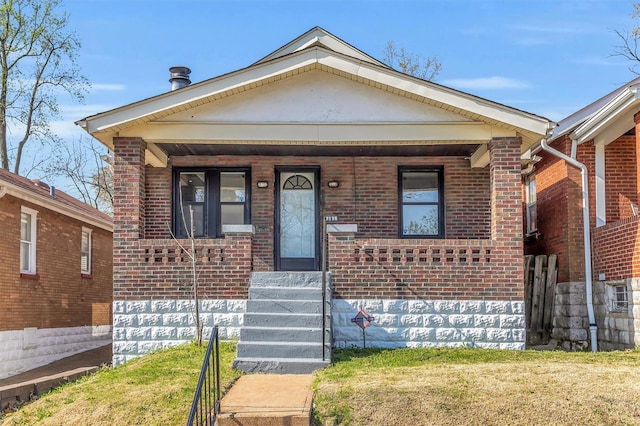 bungalow-style home featuring a porch and brick siding