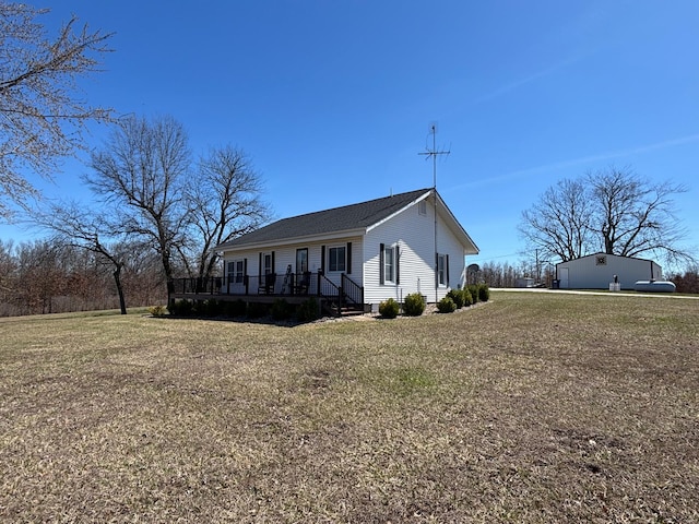 view of side of property featuring a deck and a lawn