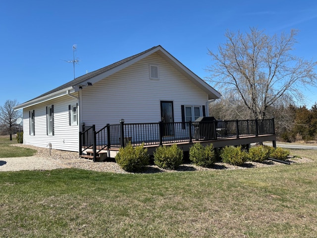 rear view of property featuring a yard and a wooden deck