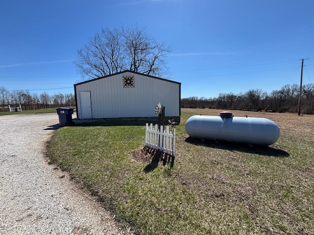 view of pole building featuring driveway and a lawn