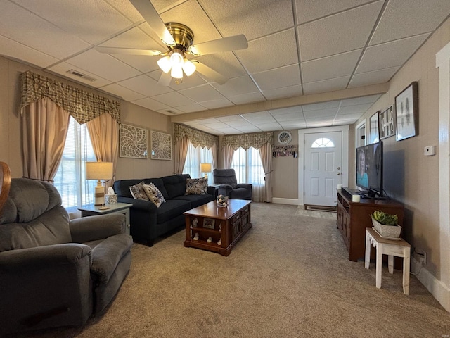 living area with carpet flooring, visible vents, baseboards, a ceiling fan, and a paneled ceiling