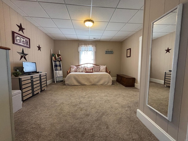 carpeted bedroom with baseboards and a paneled ceiling