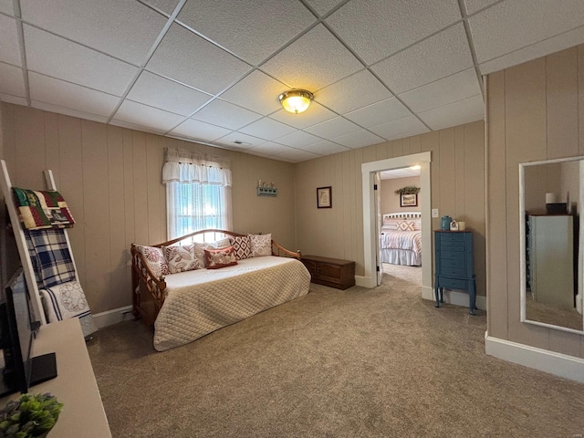 bedroom with a drop ceiling, carpet floors, and baseboards