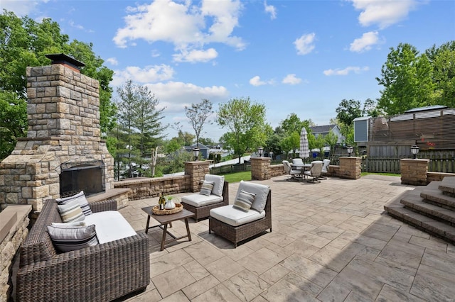 view of patio with outdoor dining space and an outdoor living space with a fireplace