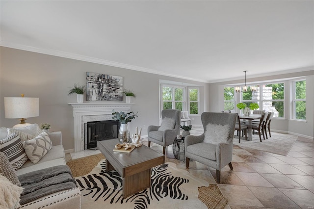 living area featuring crown molding, baseboards, a notable chandelier, and a fireplace