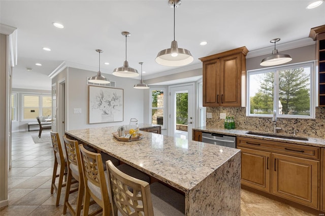 kitchen with brown cabinets, a sink, a center island, tasteful backsplash, and stainless steel dishwasher