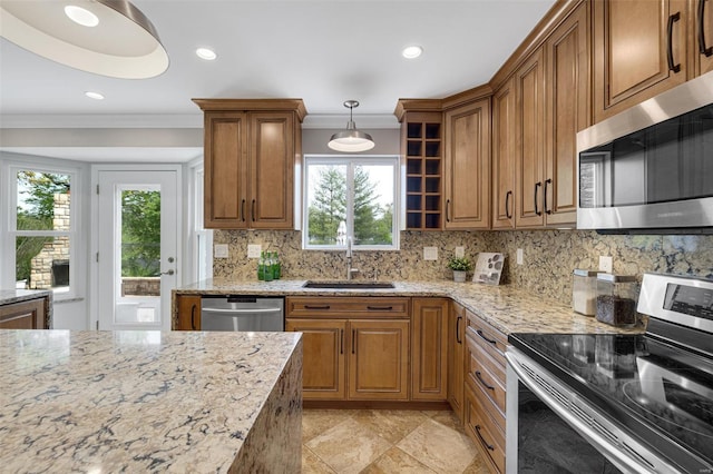 kitchen featuring a sink, brown cabinets, a wealth of natural light, and stainless steel appliances