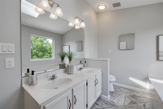 bathroom featuring visible vents, a sink, baseboards, and double vanity