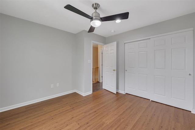 unfurnished bedroom featuring baseboards, light wood-style flooring, ceiling fan, and a closet