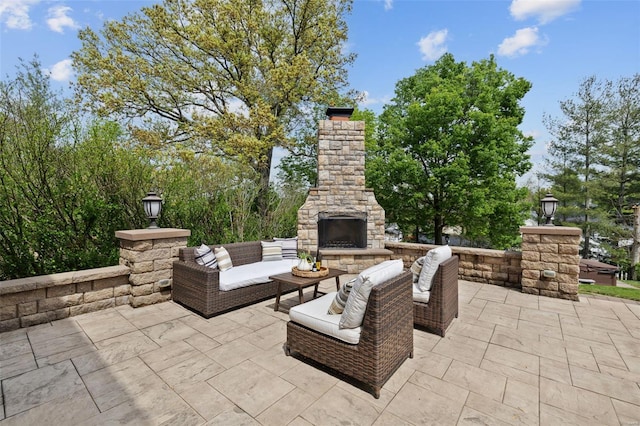 view of patio with an outdoor living space with a fireplace
