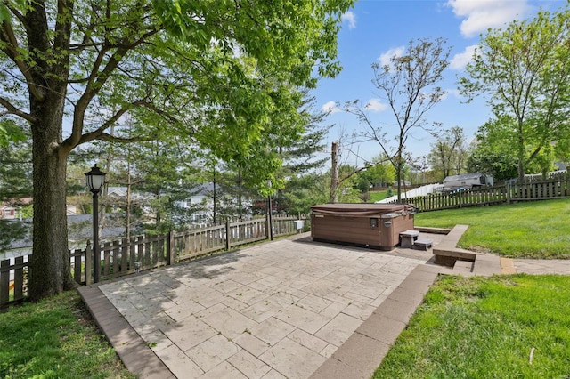 view of patio / terrace with a hot tub and a fenced backyard