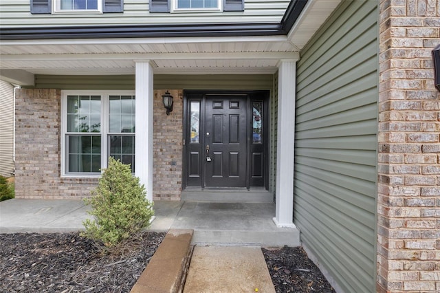 property entrance featuring brick siding