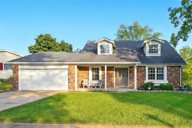 cape cod house featuring an attached garage, brick siding, a front yard, concrete driveway, and covered porch