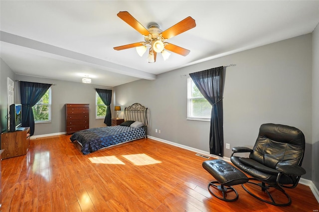 bedroom with light wood-style floors, baseboards, ceiling fan, and visible vents