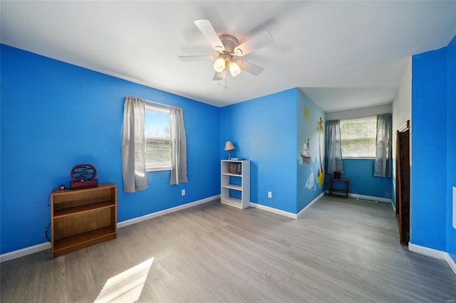 unfurnished bedroom with baseboards, a ceiling fan, and wood finished floors