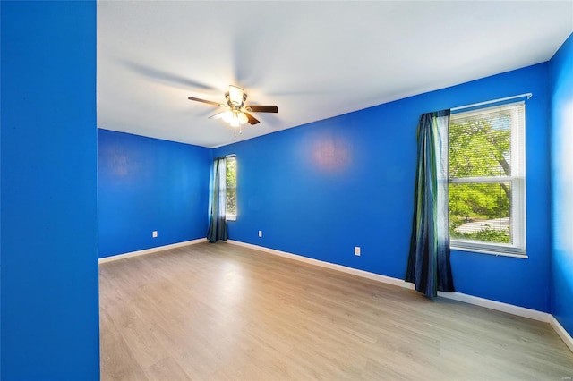 spare room with baseboards, ceiling fan, and wood finished floors