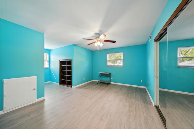 spare room featuring baseboards, a ceiling fan, wood finished floors, and visible vents