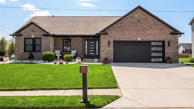 view of front of house featuring an attached garage, concrete driveway, a front yard, and brick siding