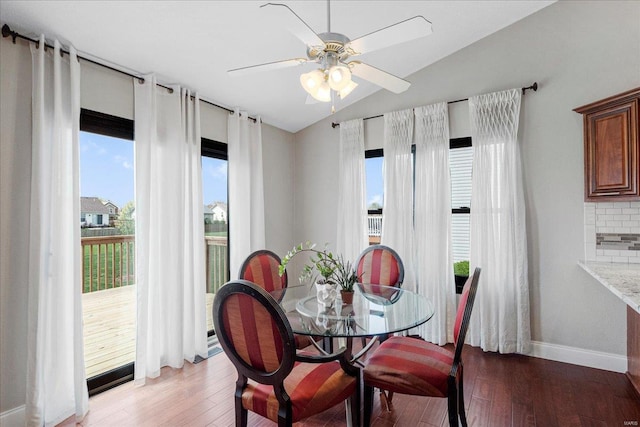 dining space with light wood-style flooring, plenty of natural light, baseboards, and lofted ceiling