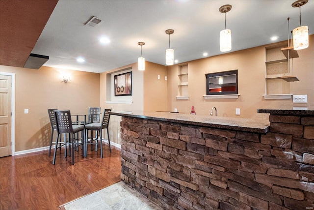 bar featuring bar area, baseboards, recessed lighting, visible vents, and wood finished floors