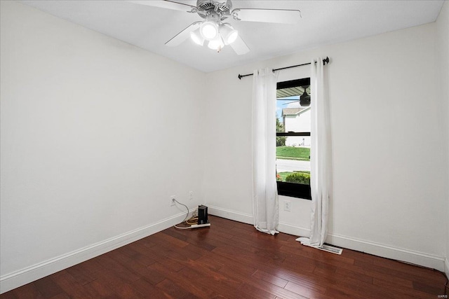 spare room with baseboards, ceiling fan, and wood finished floors