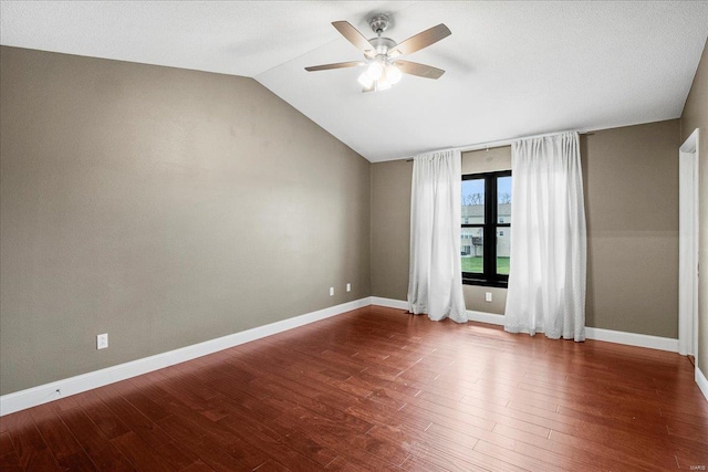 empty room with baseboards, a ceiling fan, wood finished floors, and lofted ceiling