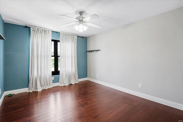 unfurnished room with baseboards, a ceiling fan, wood finished floors, and a textured ceiling