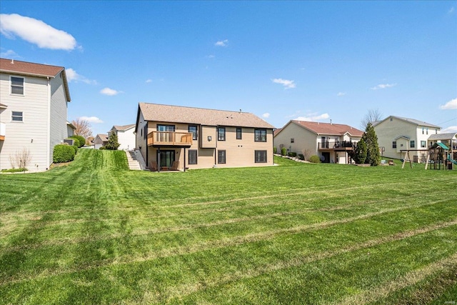 back of house featuring a residential view, a playground, and a lawn