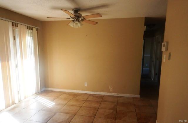 unfurnished room featuring tile patterned floors, ceiling fan, and baseboards