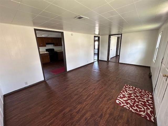 empty room featuring visible vents and dark wood-style flooring