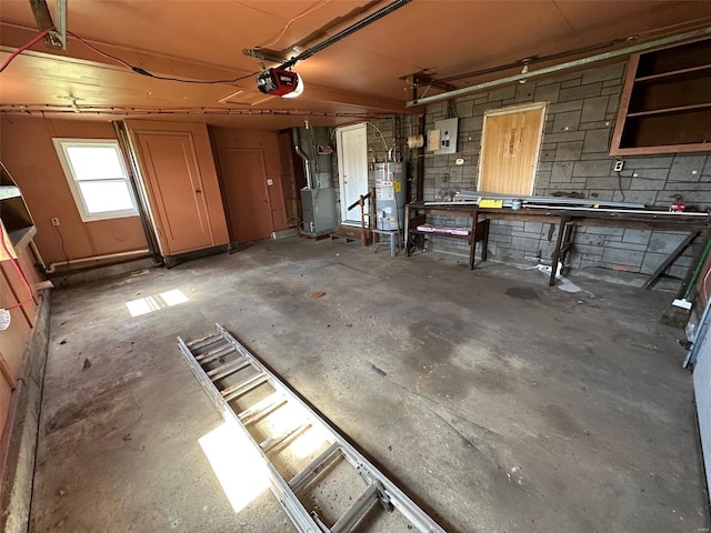 garage with heating unit, a garage door opener, concrete block wall, and gas water heater