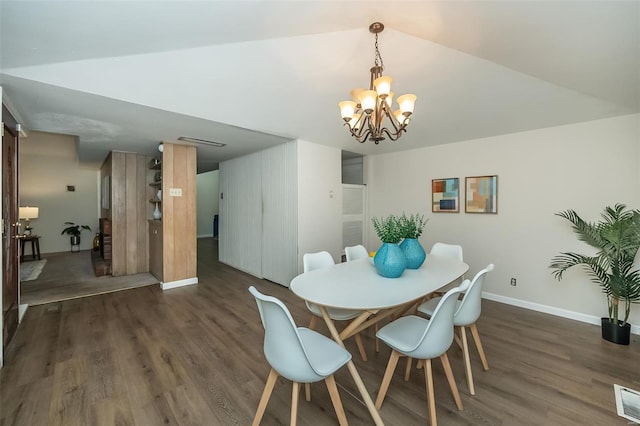 dining room with baseboards, vaulted ceiling, an inviting chandelier, and wood finished floors