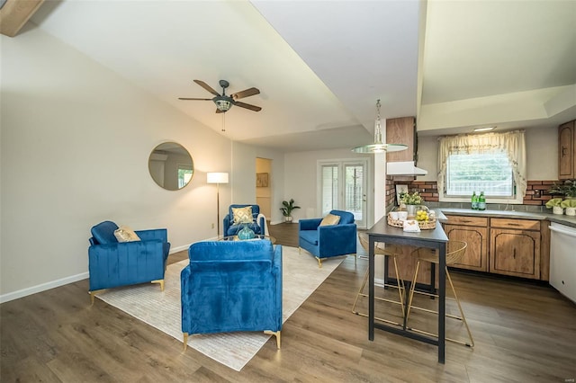 living room featuring a ceiling fan, a wealth of natural light, wood finished floors, and vaulted ceiling