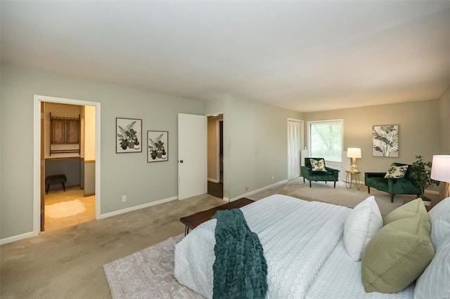 bedroom with connected bathroom, carpet floors, and baseboards