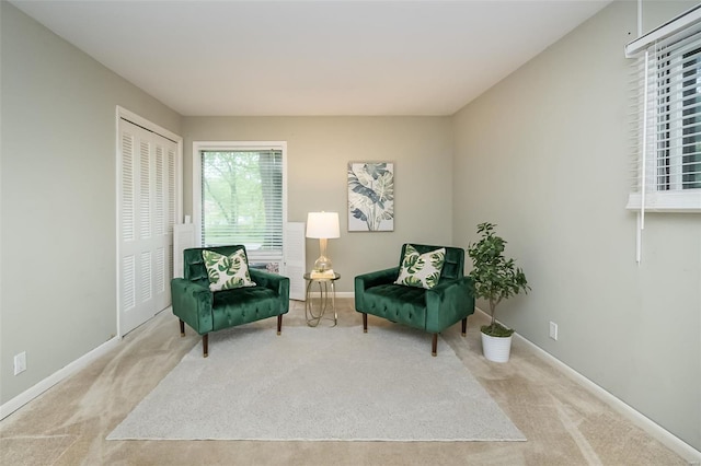 sitting room featuring carpet and baseboards