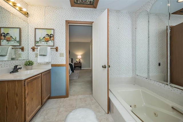 full bathroom featuring ensuite bath, vanity, wallpapered walls, and a whirlpool tub