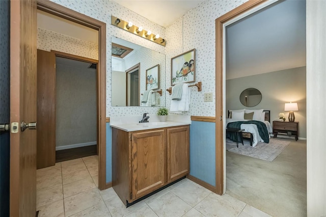 bathroom with wallpapered walls, connected bathroom, baseboards, and vanity
