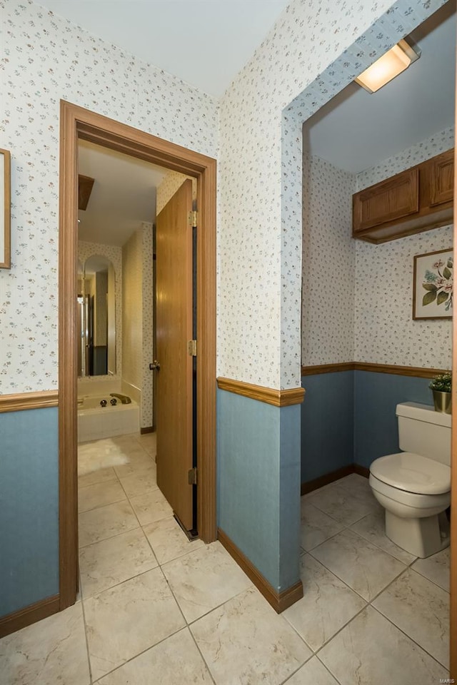 bathroom featuring toilet, baseboards, tile patterned floors, and wallpapered walls