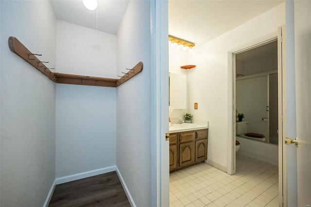 full bathroom featuring toilet, tile patterned flooring, vanity, and baseboards
