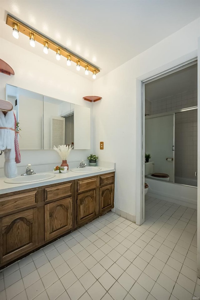 full bath featuring a sink, tile patterned flooring, toilet, and double vanity