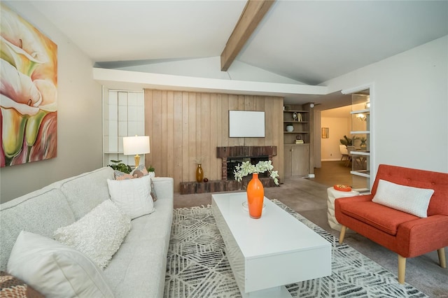 living area featuring built in features, a fireplace, and vaulted ceiling with beams